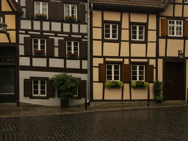 Ruhige Dorfstraße in Franken mit verputzten Häusern und unauffälligem Büroeingang